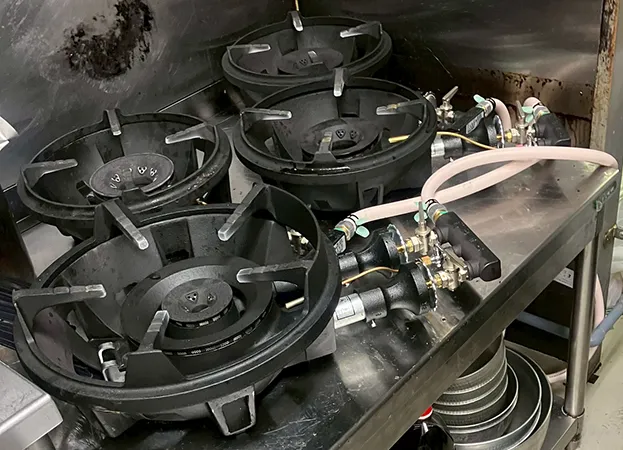 業務用の強火力ガスバーナーが並ぶ厨房設備。炒め物や煮込みに最適。